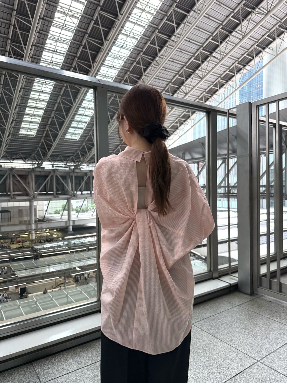 ベージュ系のタンクトップ、ブラック系のスラックス、ブラック系のローファーを着用したレディースの夏コーディネートの3枚目の写真