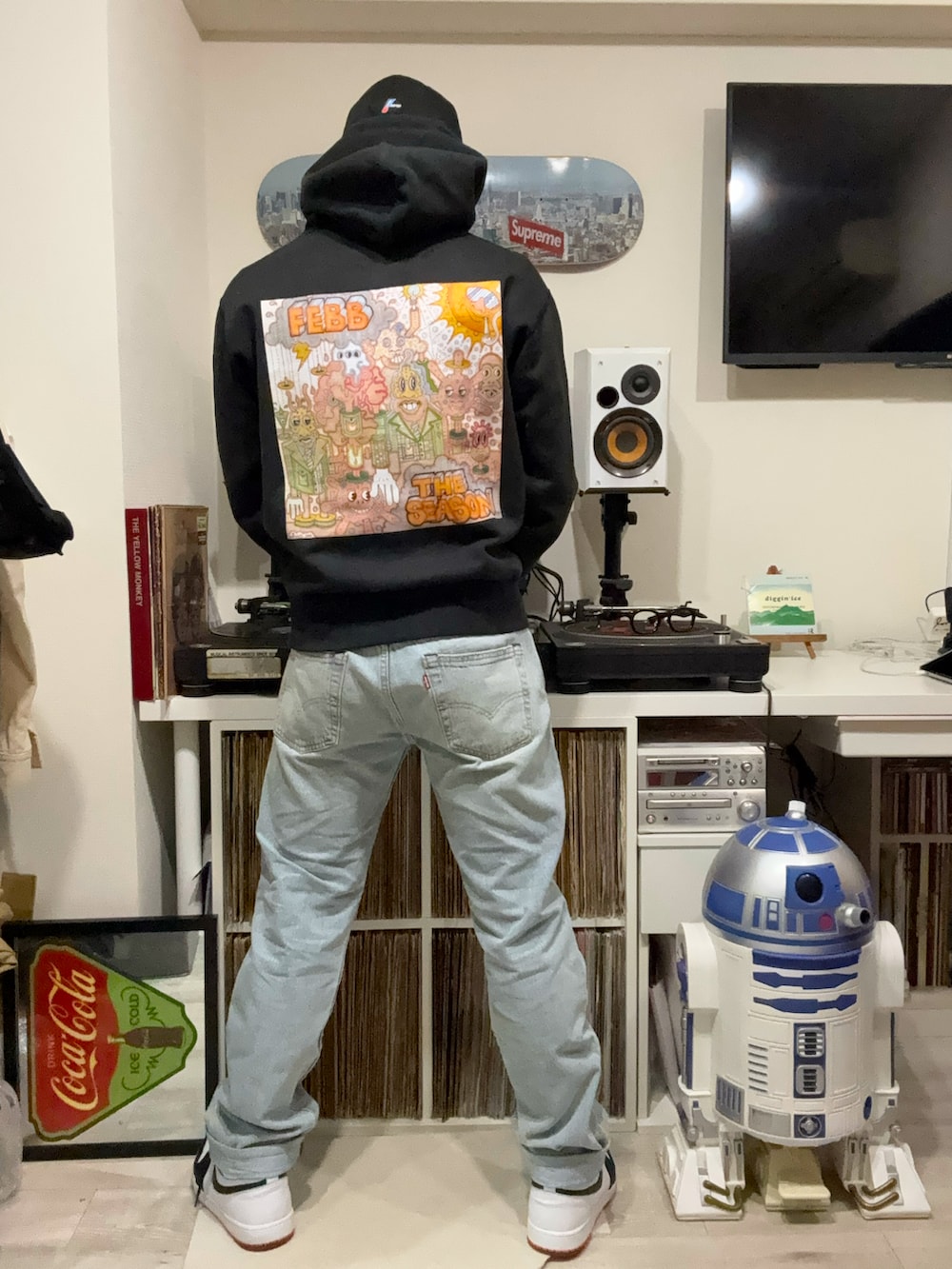 オレンジ系のダウンジャケット/コート、ブラック系のパーカー、ブルー系のデニムパンツを着用したメンズの春コーディネートの2枚目の写真