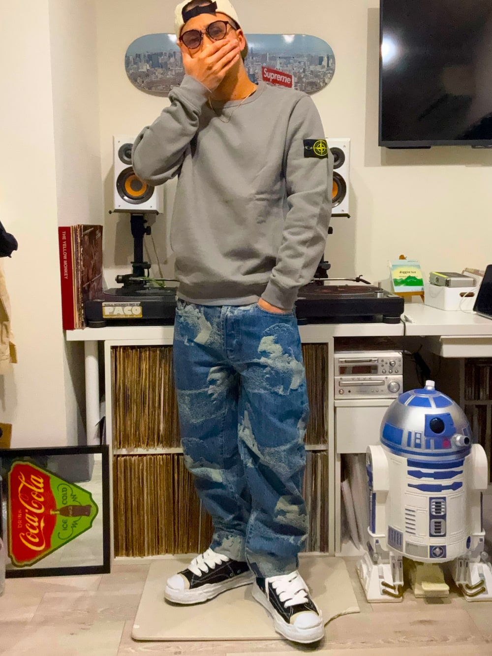 グレー系のスウェット、ベージュ系のダウンジャケット/コート、ブルー系のデニムパンツを着用したメンズの春コーディネートの2枚目の写真