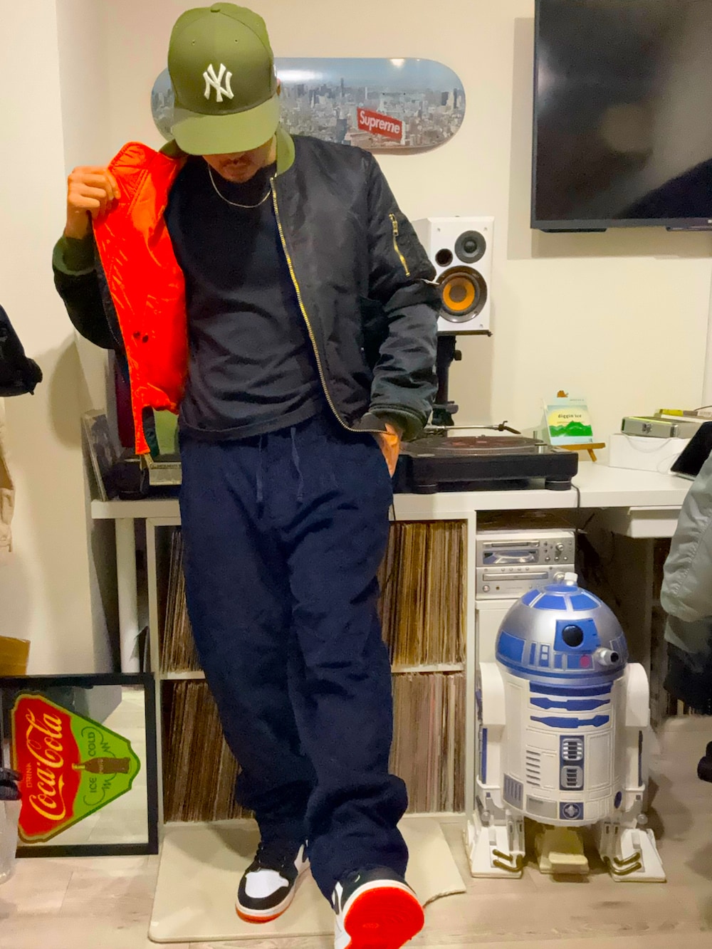 ブラック系のMA-1、ブラック系のチノパンツ、オレンジ系のスニーカーを着用したメンズの春コーディネートの3枚目の写真