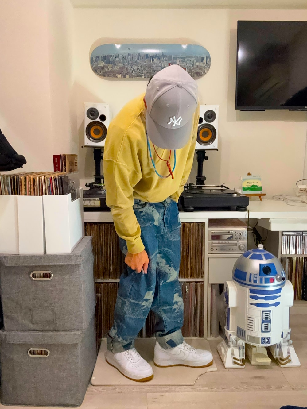 ベージュ系のスウェット、ブルー系のデニムパンツ、ホワイト系のスニーカーを着用したメンズの春コーディネートの2枚目の写真