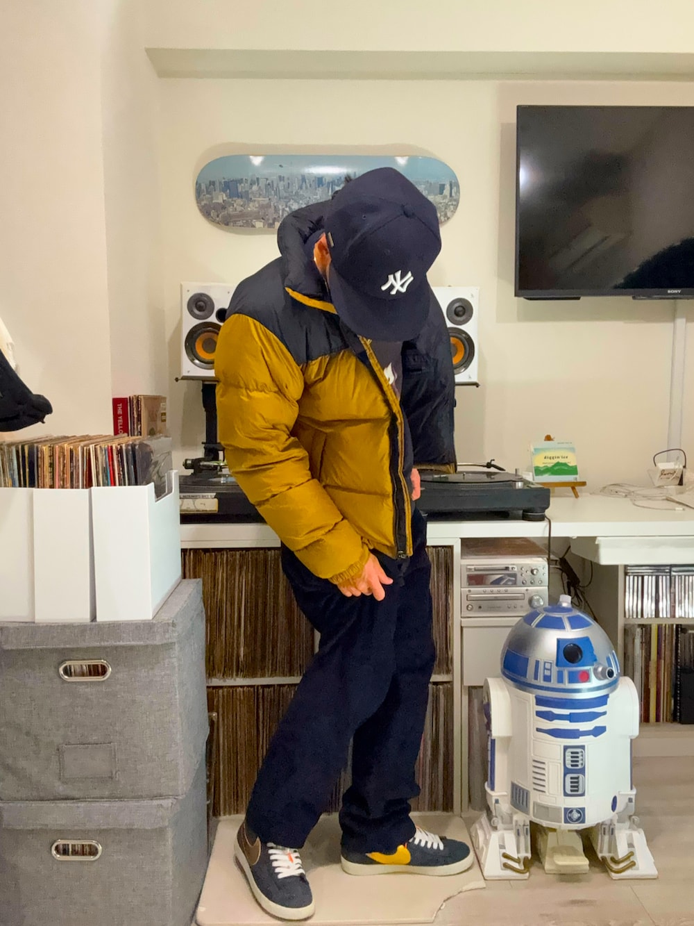 ブルー系のTシャツ/カットソー、イエロー系のダウンジャケット/コート、ブルー系のその他パンツを着用したメンズの春コーディネートの2枚目の写真