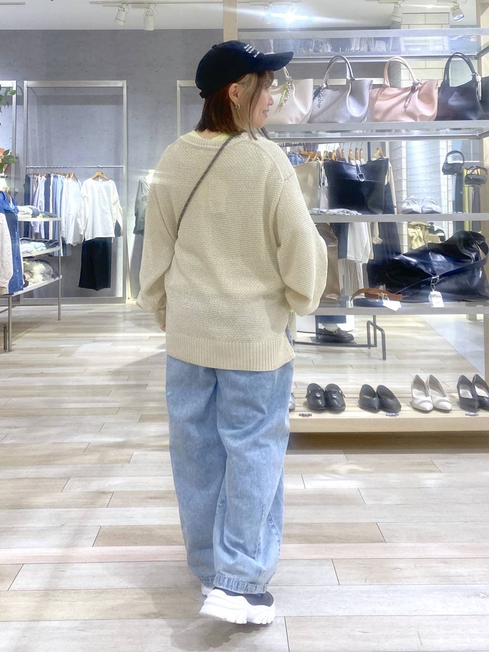 イエロー系のTシャツ/カットソー、ベージュ系のニット/セーター、ブラック系のサンダルを着用したレディースの春コーディネートの5枚目の写真