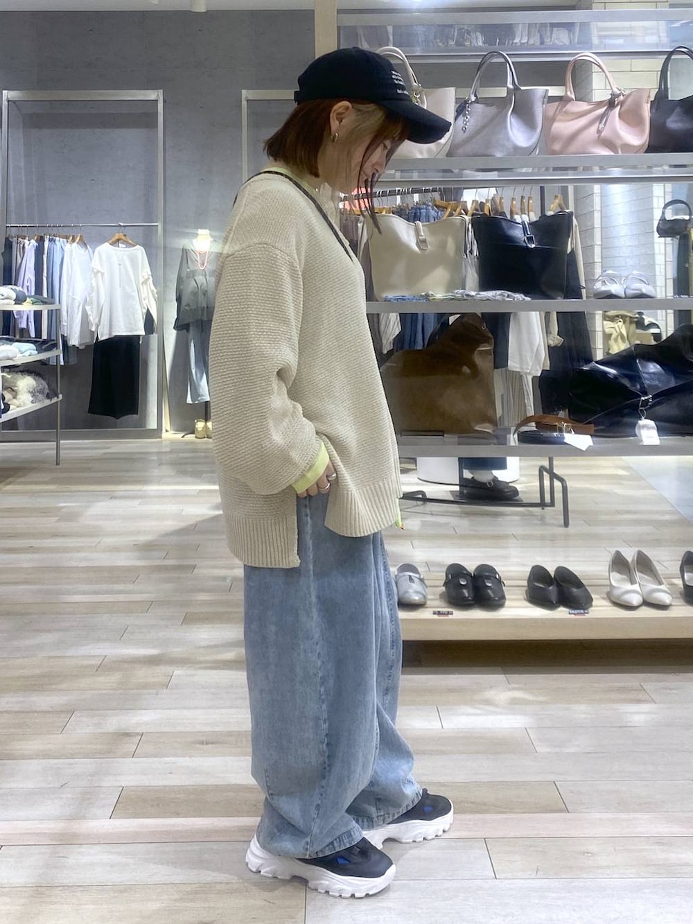 イエロー系のTシャツ/カットソー、ベージュ系のニット/セーター、ブラック系のサンダルを着用したレディースの春コーディネートの4枚目の写真