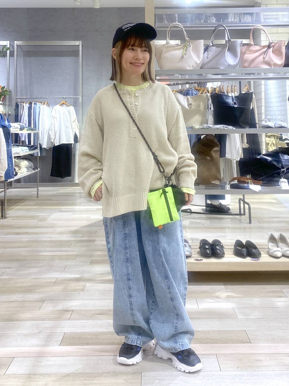 イエロー系のTシャツ/カットソー、ベージュ系のニット/セーター、ブラック系のサンダルを着用したレディースの春コーディネートの3枚目の写真