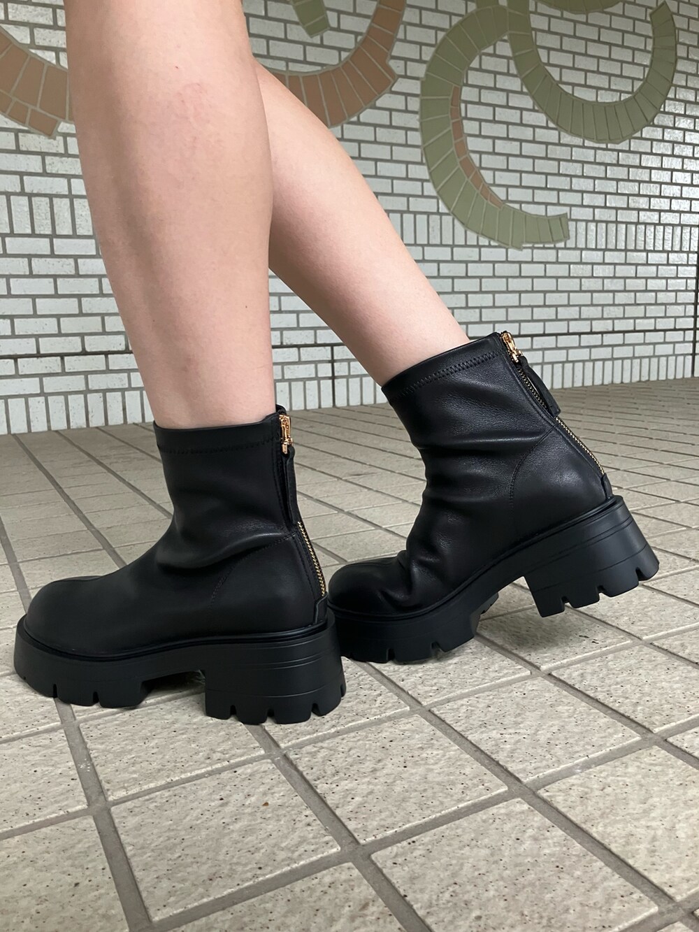 ブラック系のブーツを着用したレディースの秋コーディネートの2枚目の写真