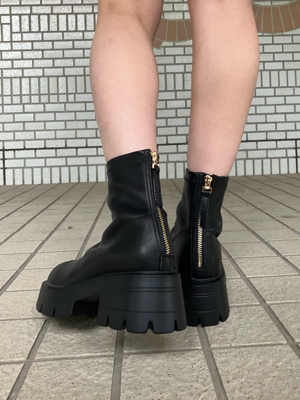 ブラック系のブーツを着用したレディースの秋コーディネートの3枚目の写真