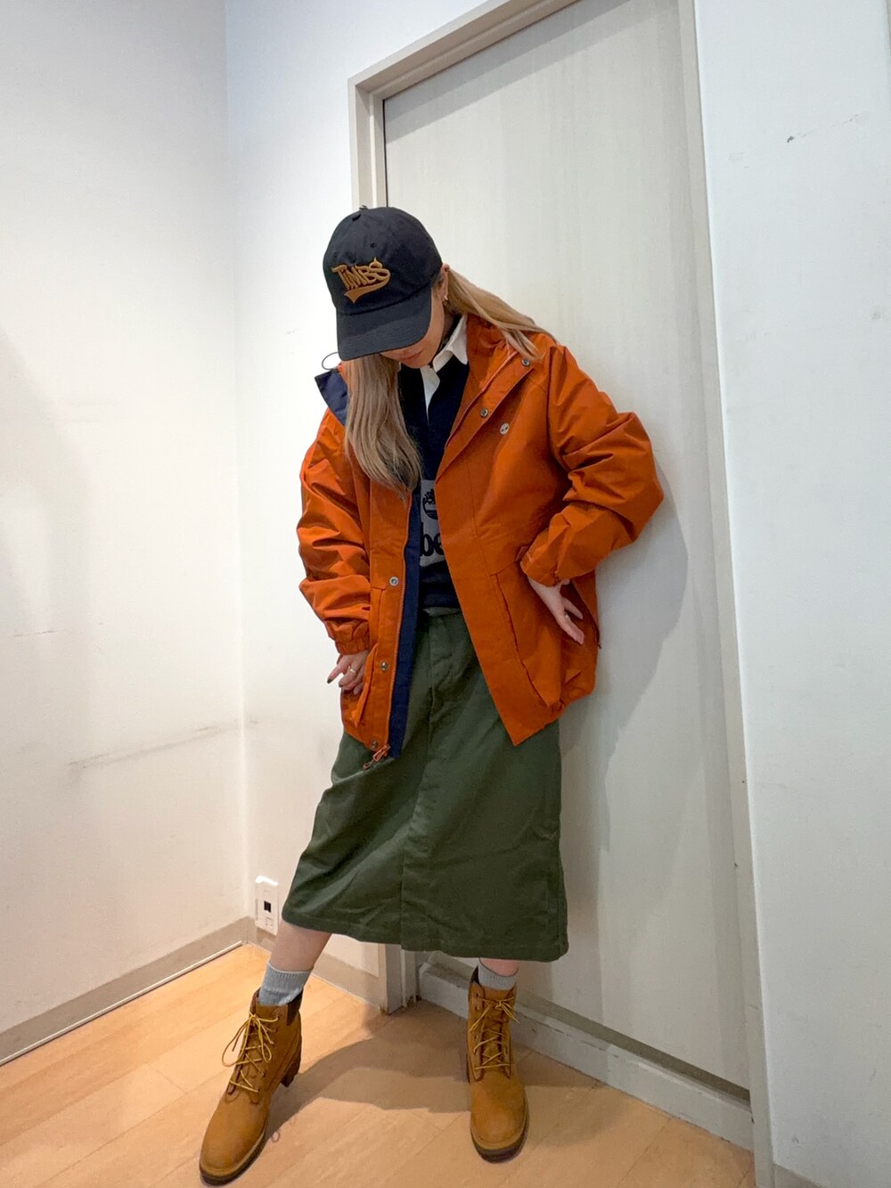 ブルー系のその他トップス、ベージュ系のブーツ、オレンジ系のジャケット/アウターを着用したレディースの秋コーディネートの2枚目の写真