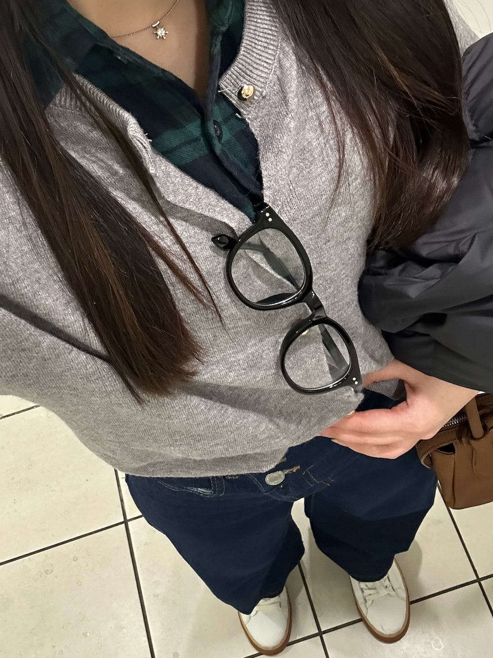 ブルー系のデニムパンツ、ホワイト系のスニーカー、ブラウン系のバッグを着用したレディースの春コーディネートの2枚目の写真