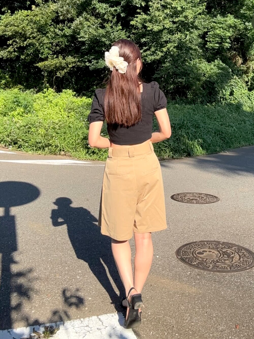 ブラック系のトップス、その他のハンドバッグ、ベージュ系のその他パンツを着用したレディースの夏コーディネートの2枚目の写真