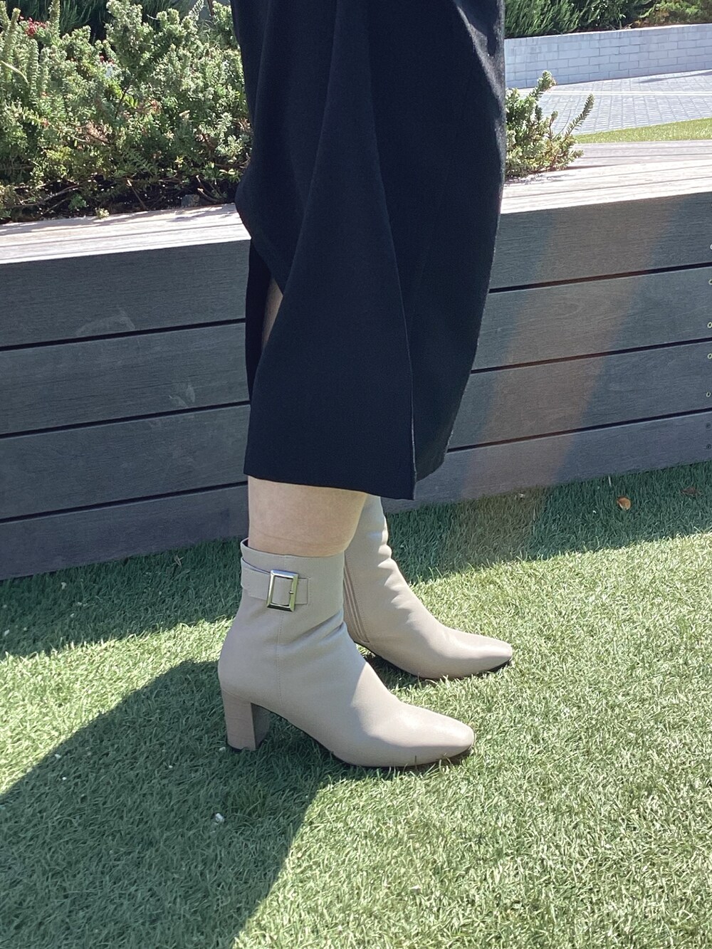 ホワイト系のブーツを着用したレディースの秋コーディネートの2枚目の写真