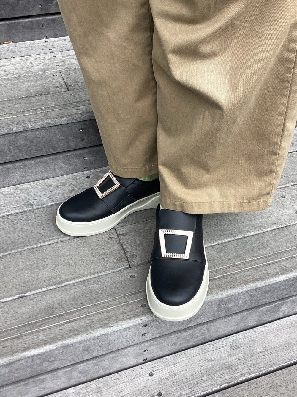 ブラック系のスリッポンを着用したレディースの夏コーディネートの2枚目の写真