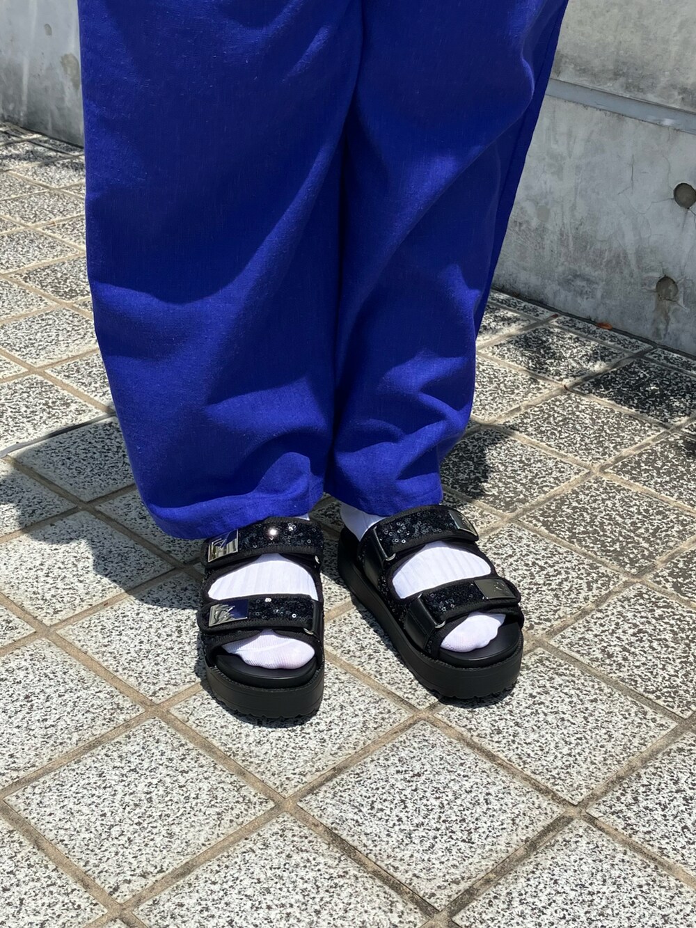ブラック系のサンダルを着用したレディースの夏コーディネートの2枚目の写真