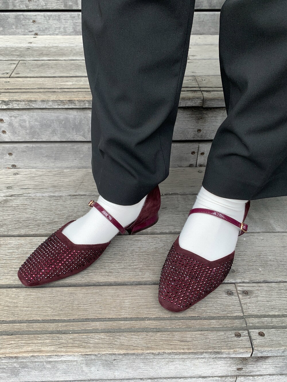 レッド系のパンプスを着用したレディースの秋コーディネートの2枚目の写真