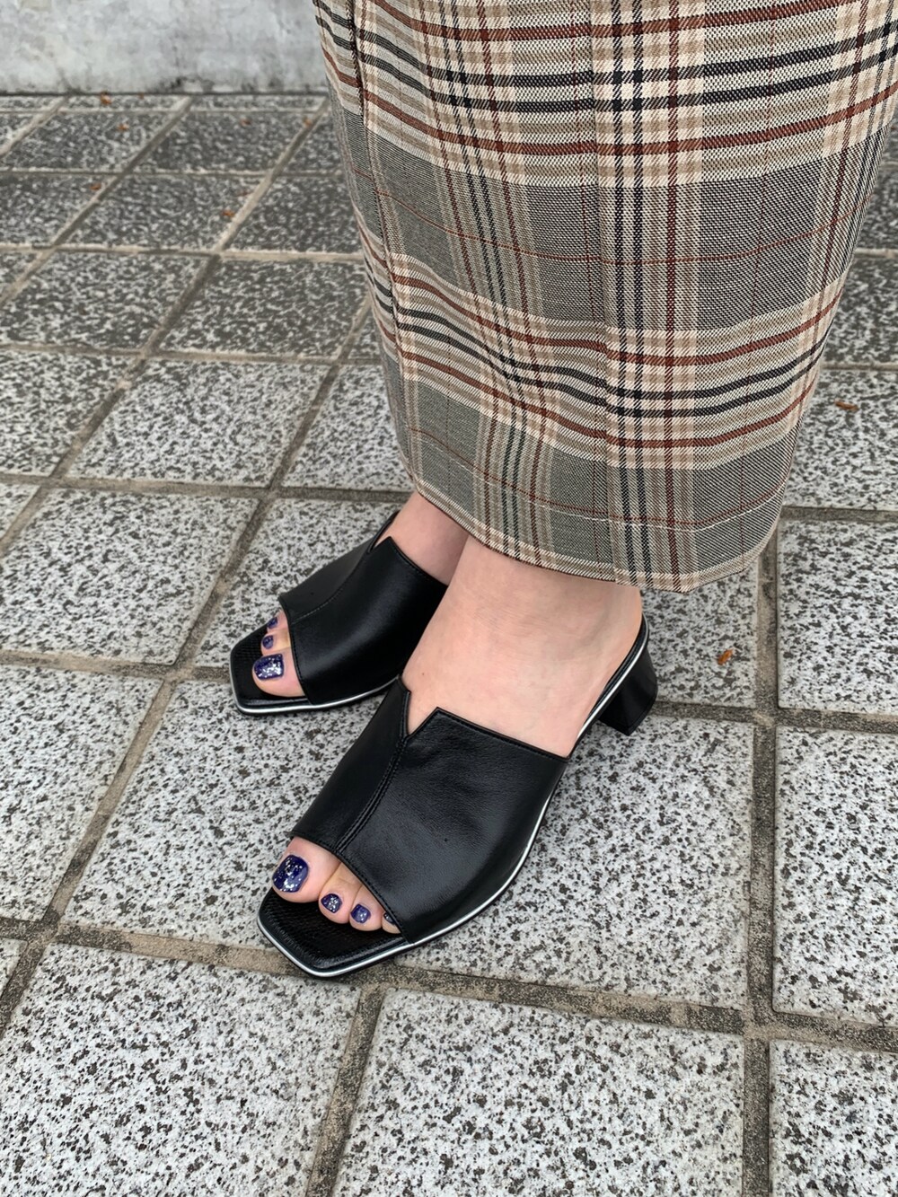 ブラック系のサンダルを着用したレディースの春コーディネートの2枚目の写真