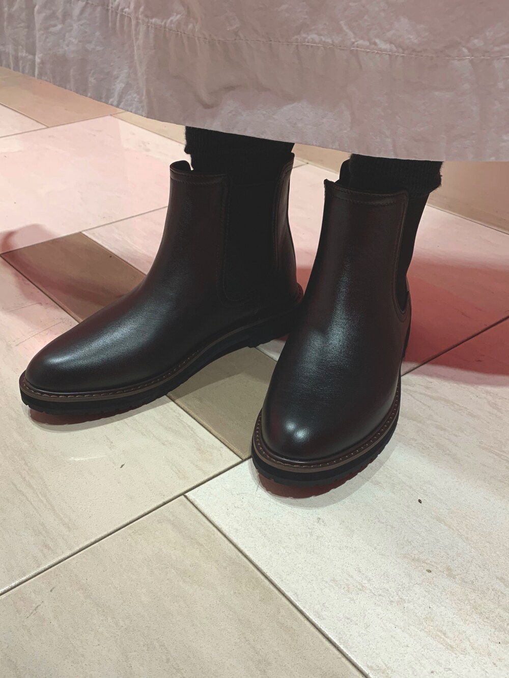 ブラック系のレインシューズを着用したレディースの秋コーディネートの2枚目の写真