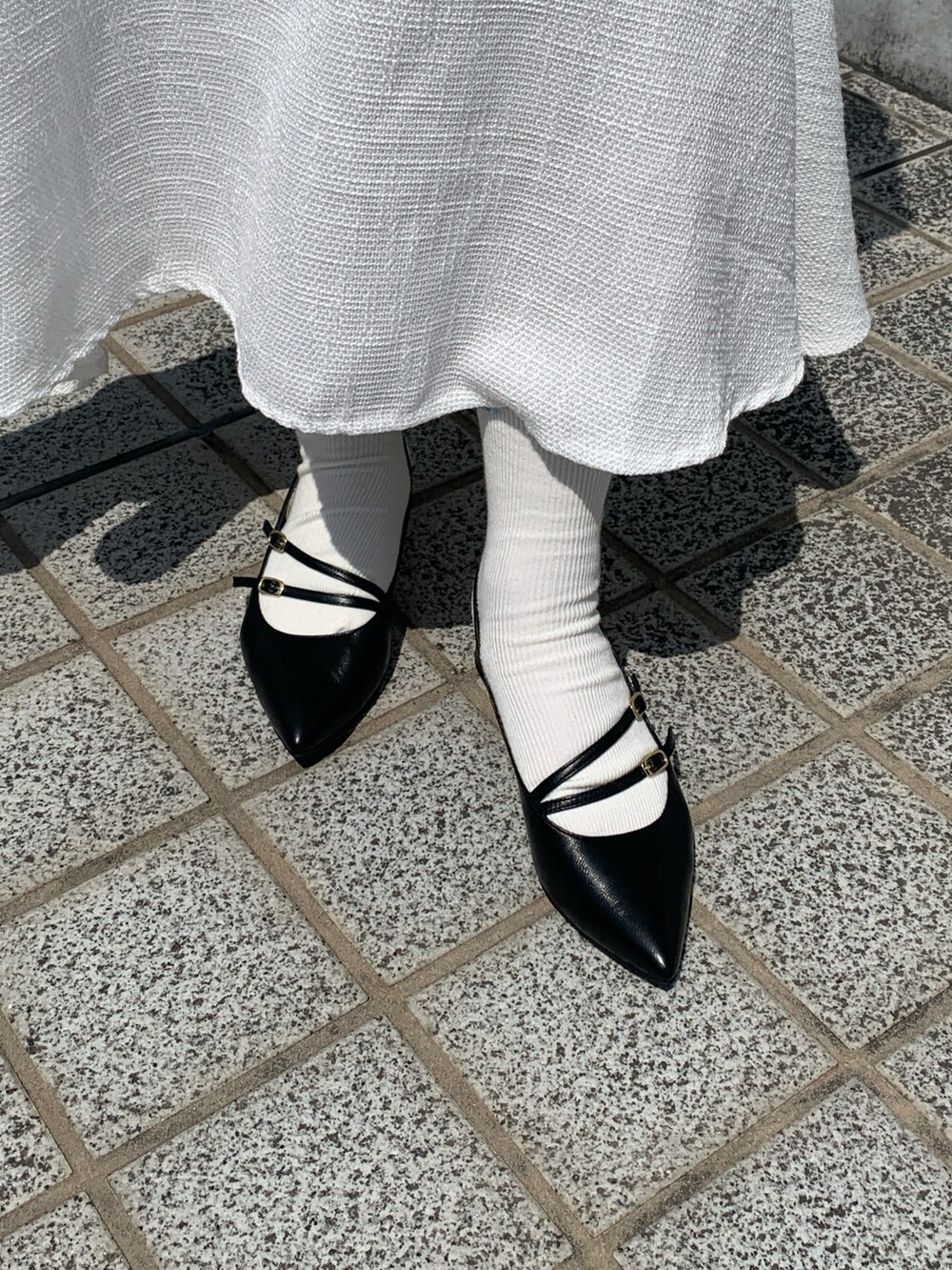 ブラック系のパンプスを着用したレディースの春コーディネートの2枚目の写真