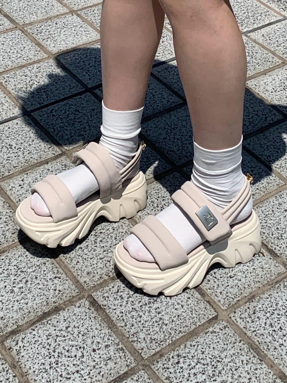 ホワイト系のサンダルを着用したレディースの春コーディネートの2枚目の写真