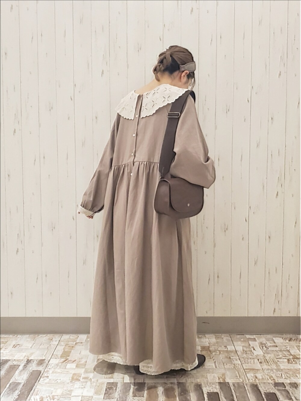 ベージュ系のワンピース、ブラウン系のハンドバッグ、ブラウン系のドレスシューズを着用したレディースの秋コーディネートの2枚目の写真