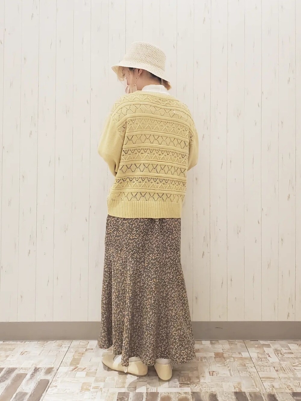 イエロー系のカーディガン/ボレロ、イエロー系のハンドバッグ、グリーン系のスカートを着用したレディースの春コーディネートの2枚目の写真