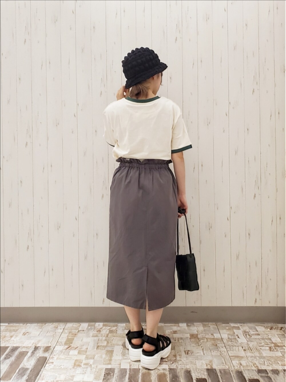 ホワイト系のTシャツ/カットソー、グレー系のスカート、ブラック系のショルダーバッグを着用したレディースの夏コーディネートの2枚目の写真