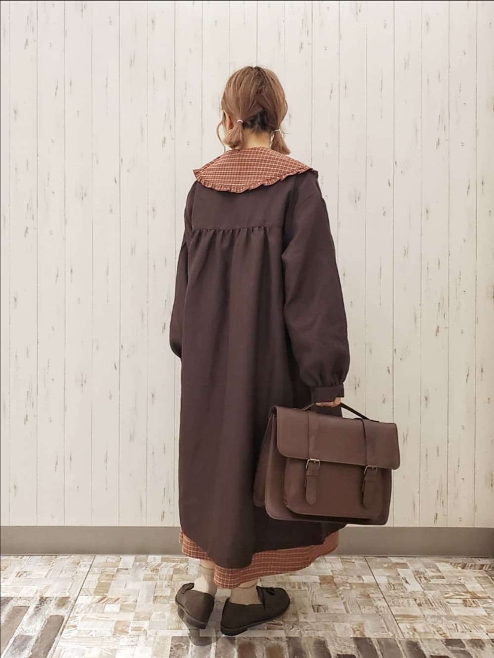 レッド系のワンピース、ブラウン系のその他アウター、ブラウン系のハンドバッグを着用したレディースの秋コーディネートの2枚目の写真