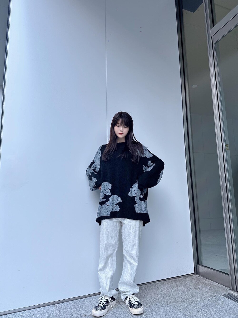 ブラック系のTシャツ/カットソー、ホワイト系のパンツ、ホワイト系のスニーカーを着用したレディースの夏コーディネートの2枚目の写真