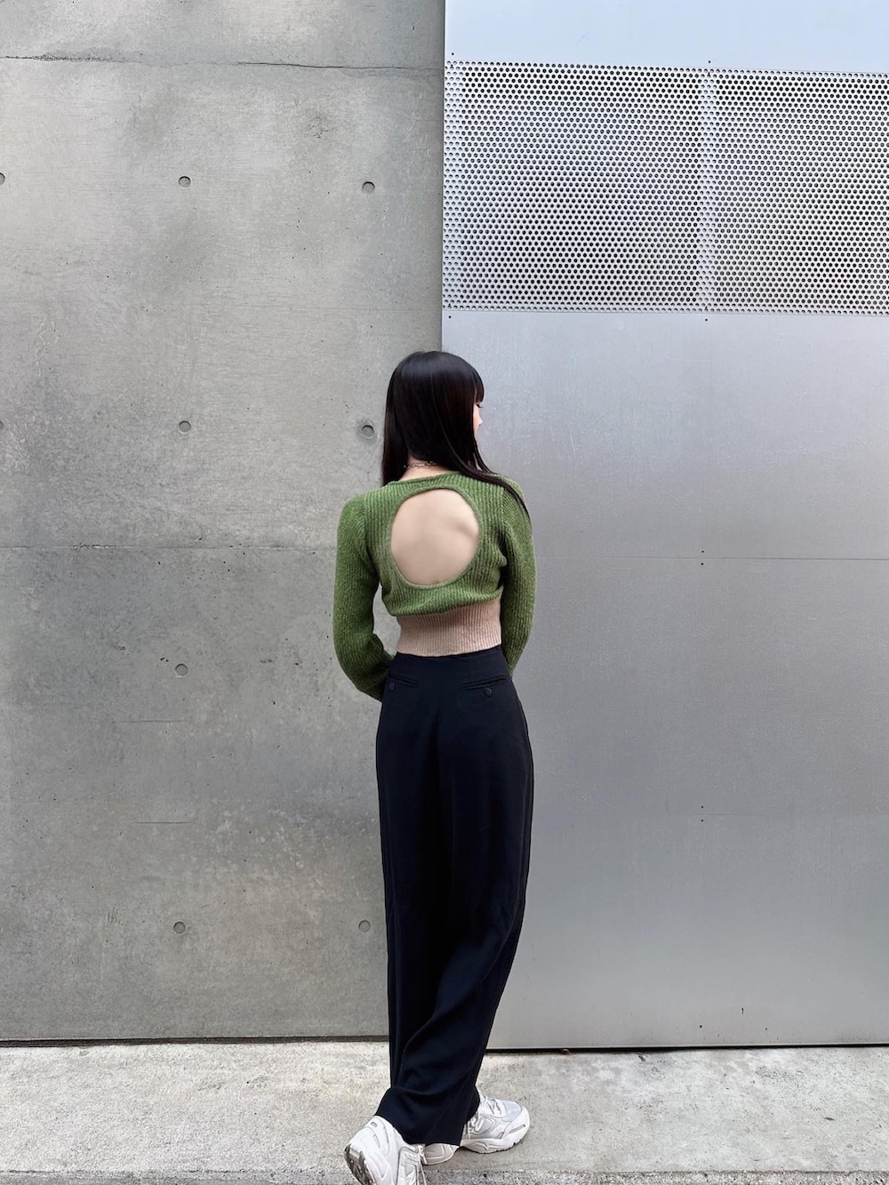 ホワイト系のハンドバッグ、ブラック系のパンツ、グリーン系のニット/セーターを着用したレディースの春コーディネートの2枚目の写真