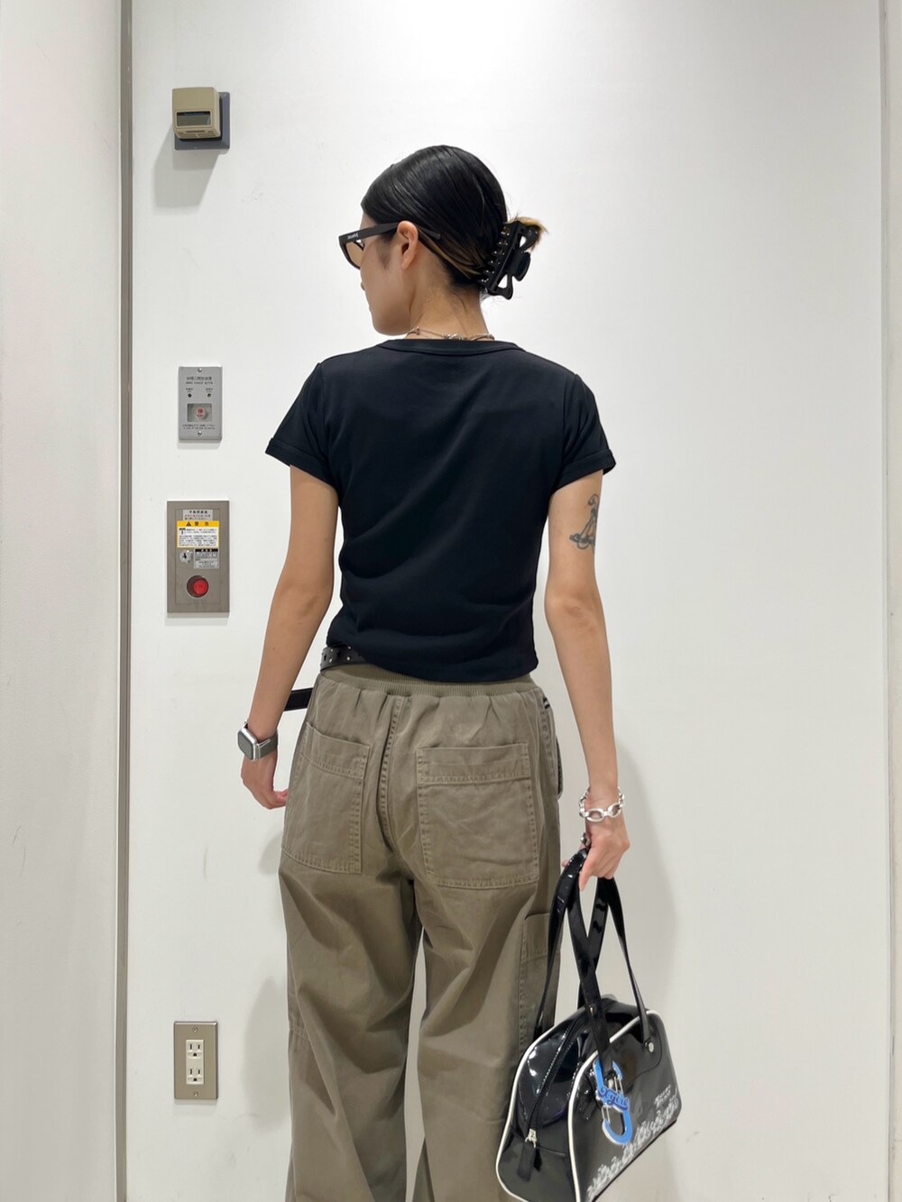 ブラック系のTシャツ/カットソー、ベージュ系のその他パンツ、ブラック系のハンドバッグを着用したレディースの夏コーディネートの4枚目の写真