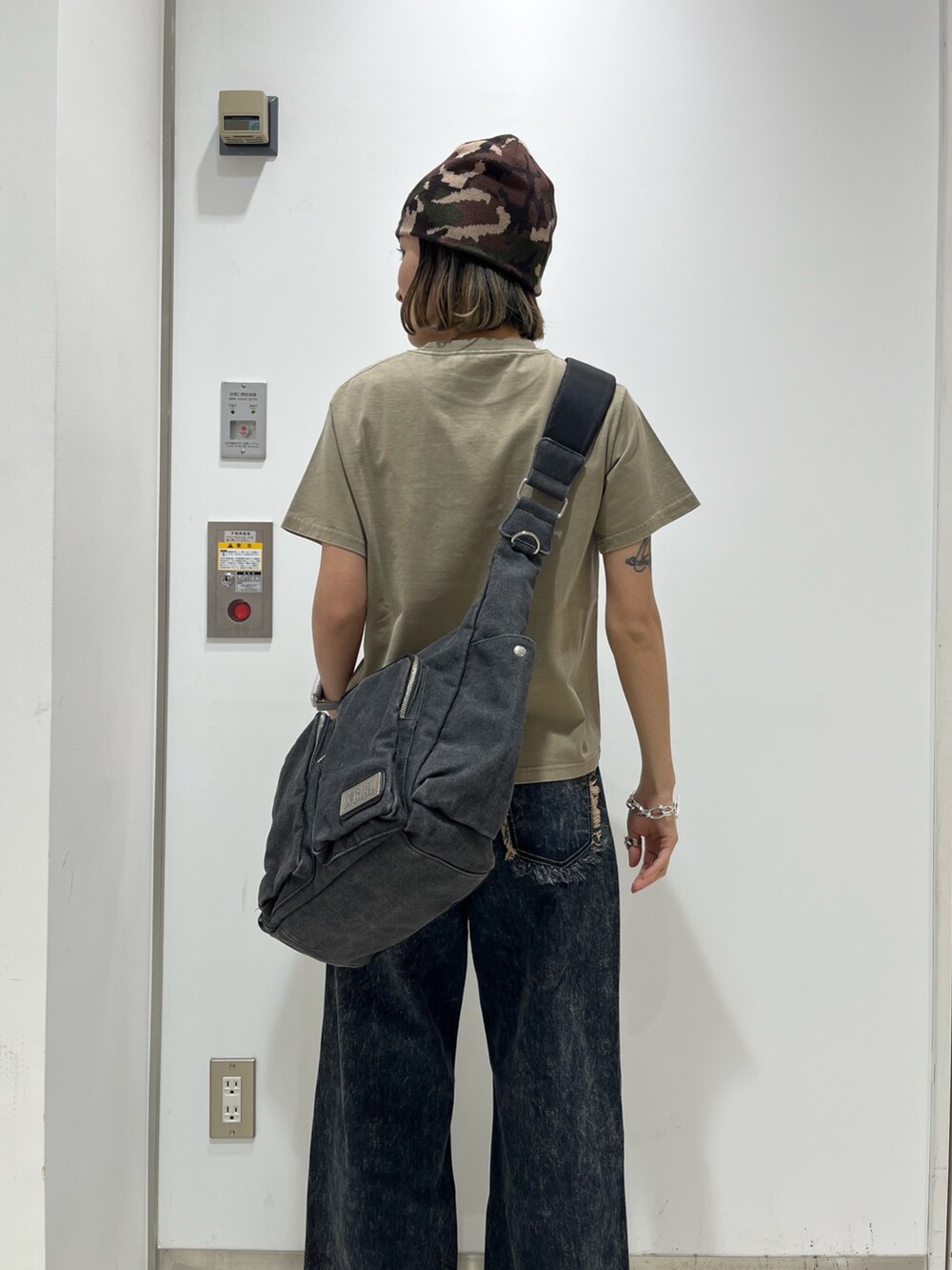 ブルー系のデニムパンツ、ベージュ系のTシャツ/カットソー、ブラック系のショルダーバッグを着用したレディースの春コーディネートの4枚目の写真