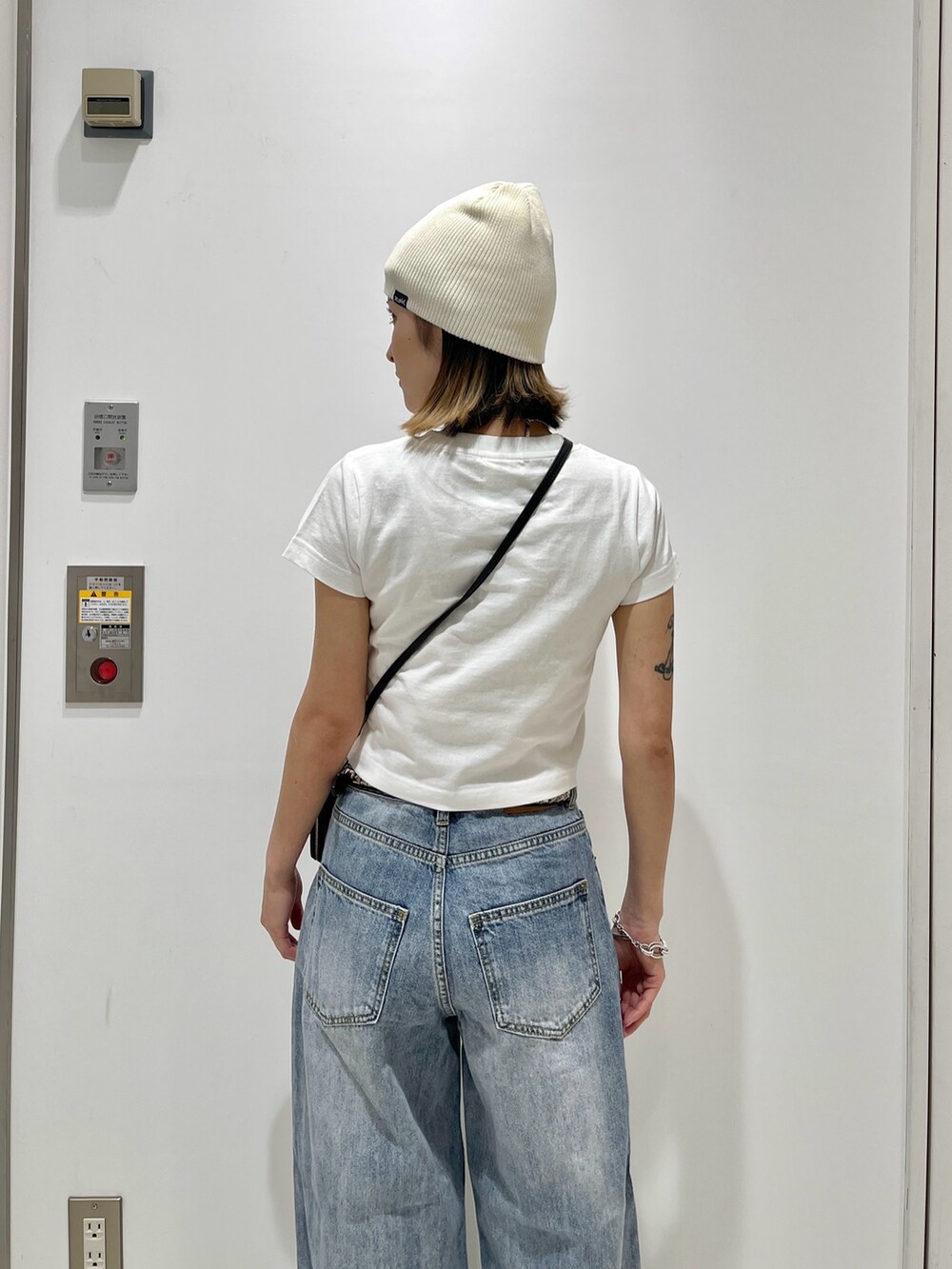 ブルー系のデニムパンツ、ホワイト系のTシャツ/カットソー、ホワイト系のニットキャップ/ビーニーを着用したレディースの夏コーディネートの4枚目の写真