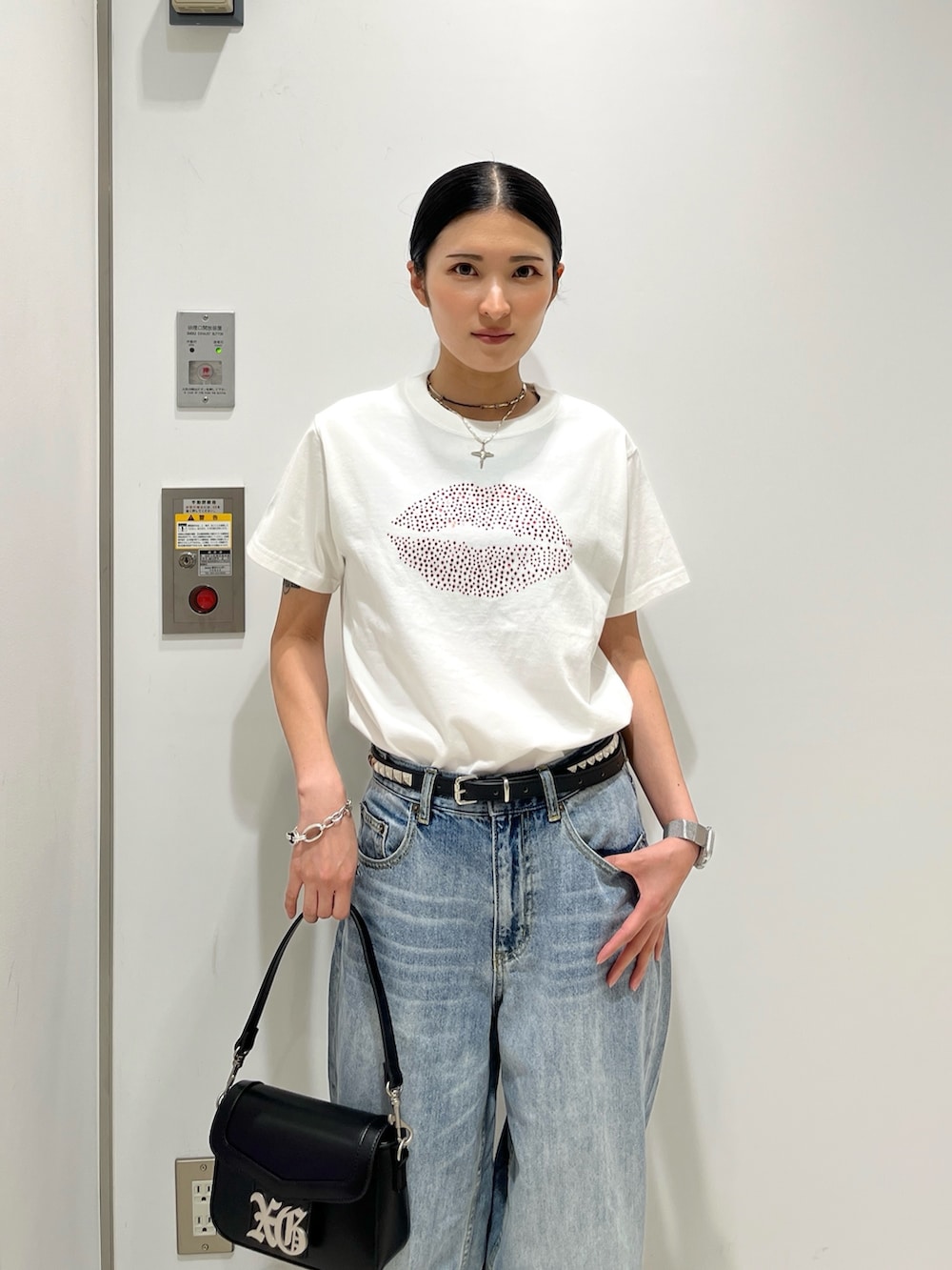 ホワイト系のTシャツ/カットソー、ブルー系のデニムパンツ、ブラック系のショルダーバッグを着用したレディースの夏コーディネートの3枚目の写真