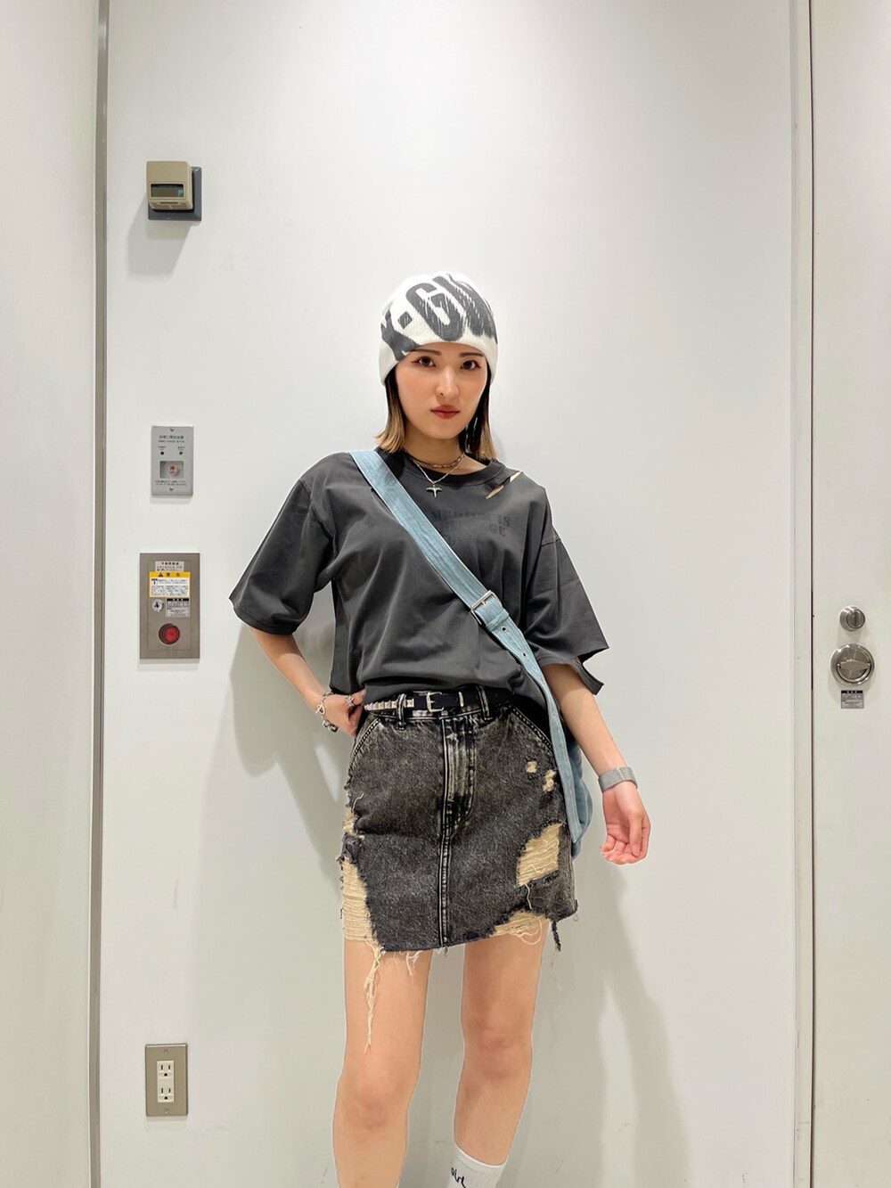 ブラック系のTシャツ/カットソー、ブラック系のデニムスカート、ブルー系のショルダーバッグを着用したレディースの夏コーディネートの3枚目の写真