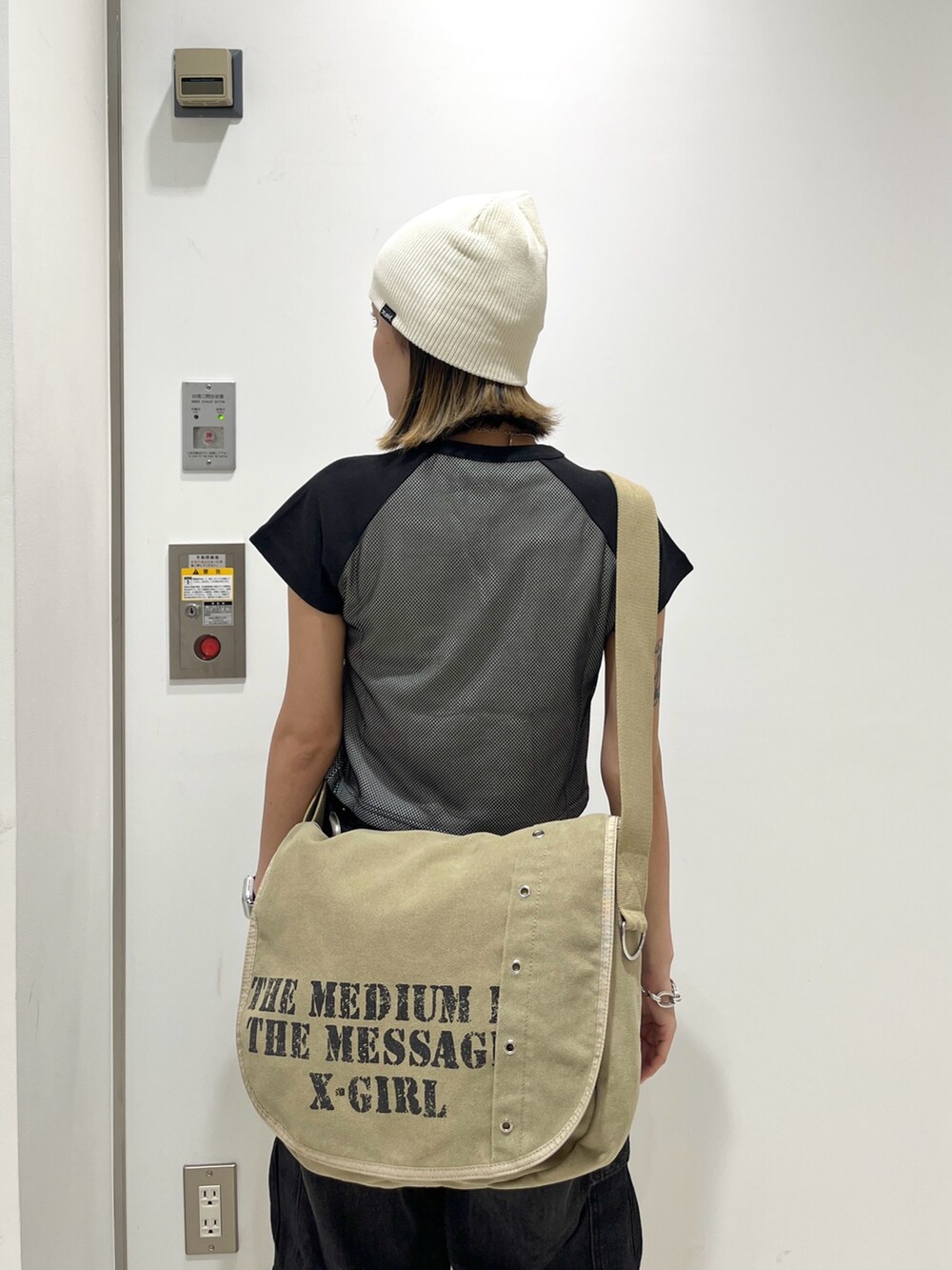 ブラック系のデニムパンツ、ブラック系のTシャツ/カットソー、ブラウン系のショルダーバッグを着用したレディースの夏コーディネートの4枚目の写真