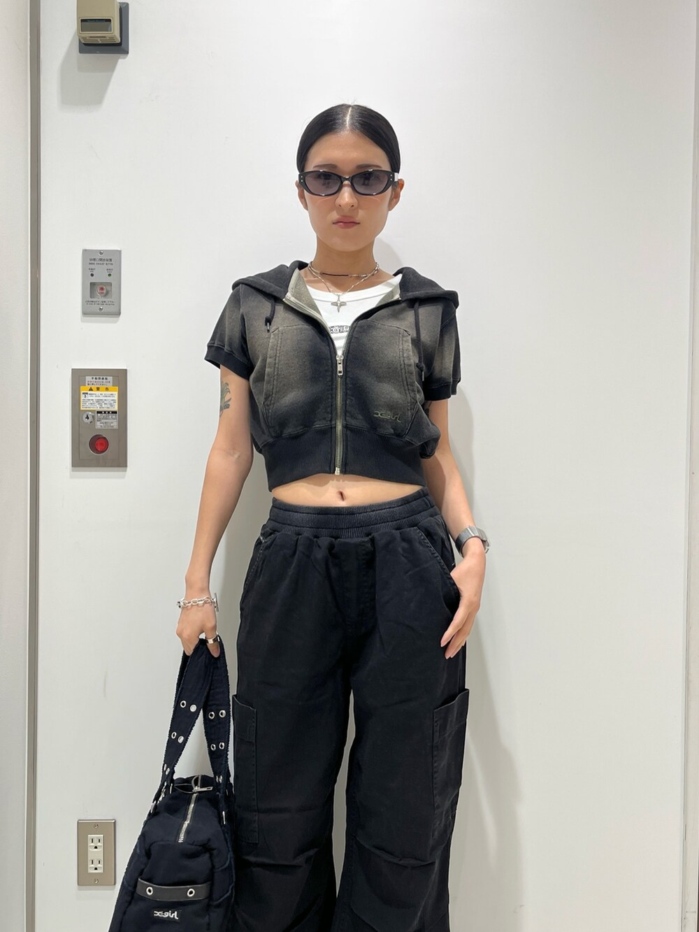 グリーン系のパーカー、ホワイト系のタンクトップ、ブラック系のその他パンツを着用したレディースの夏コーディネートの3枚目の写真