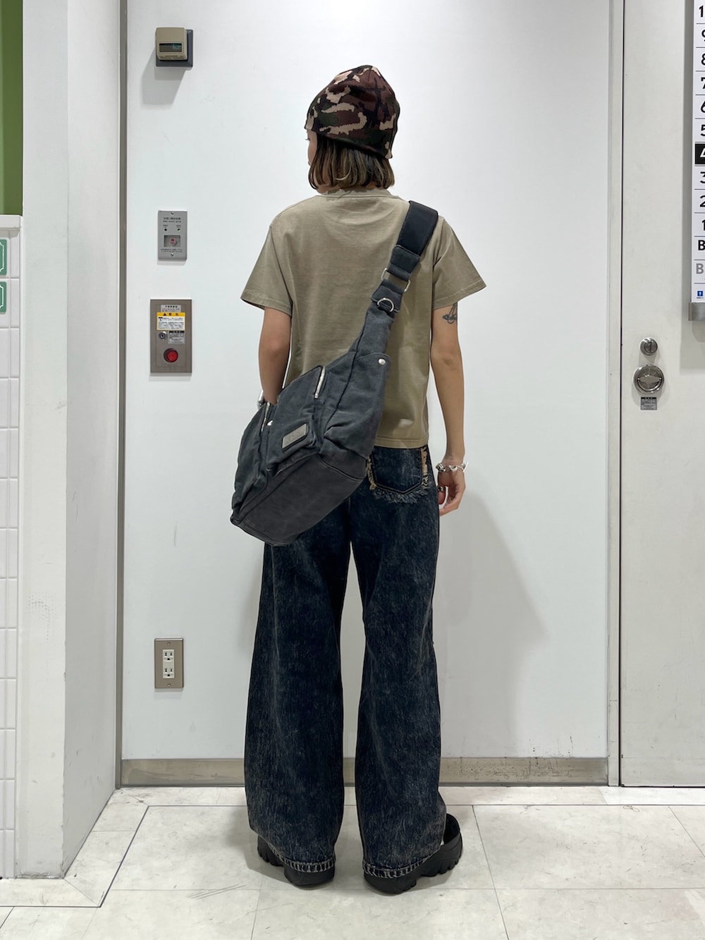 ブルー系のデニムパンツ、ベージュ系のTシャツ/カットソー、ブラック系のショルダーバッグを着用したレディースの春コーディネートの2枚目の写真