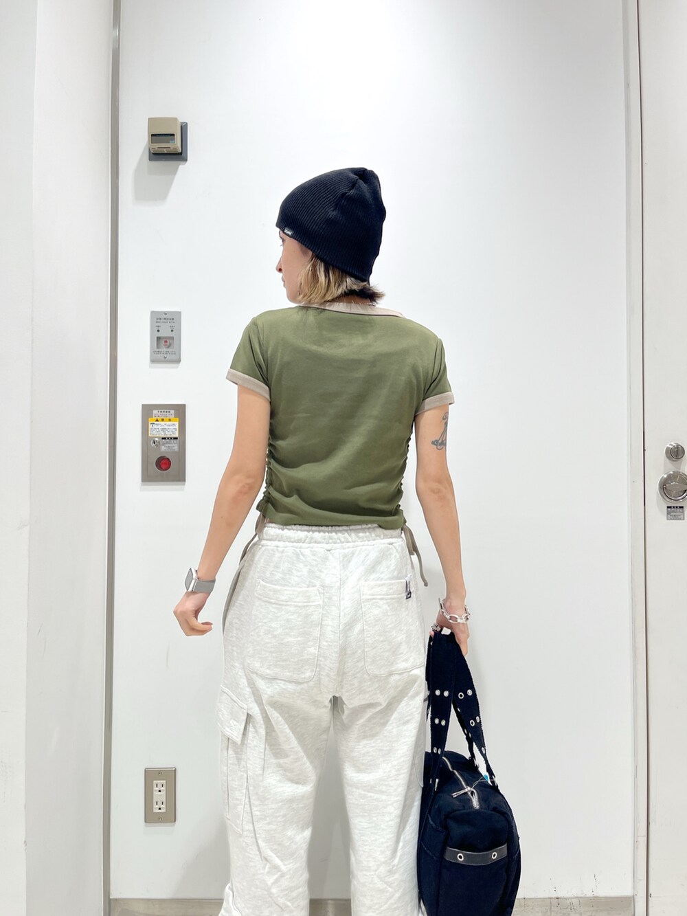 グレー系のスウェットパンツ、グリーン系のTシャツ/カットソー、ブラック系のハンドバッグを着用したレディースの春コーディネートの4枚目の写真