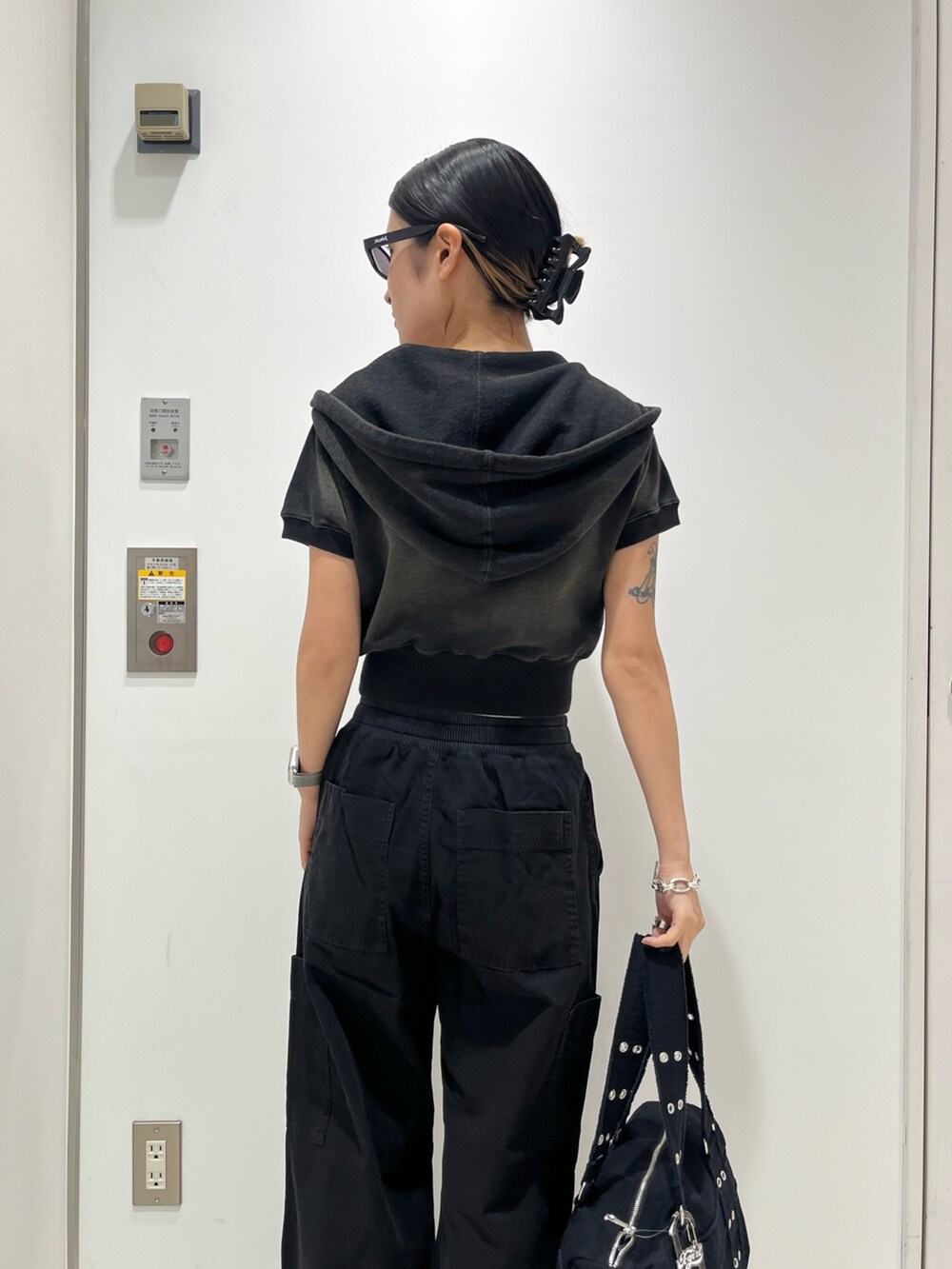 グリーン系のパーカー、ホワイト系のタンクトップ、ブラック系のその他パンツを着用したレディースの夏コーディネートの4枚目の写真