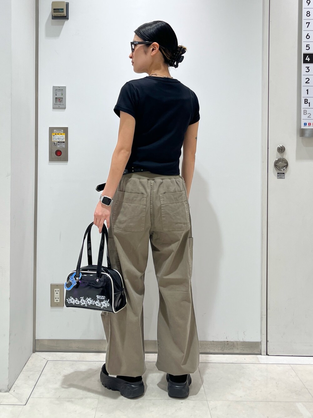 ブラック系のTシャツ/カットソー、ベージュ系のその他パンツ、ブラック系のハンドバッグを着用したレディースの夏コーディネートの2枚目の写真