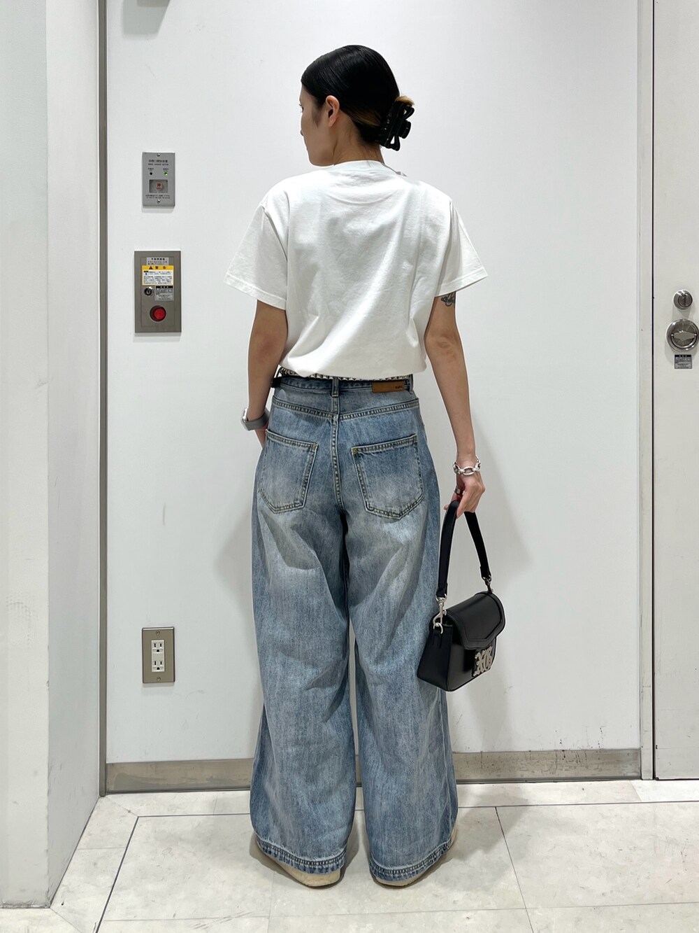 ホワイト系のTシャツ/カットソー、ブルー系のデニムパンツ、ブラック系のショルダーバッグを着用したレディースの夏コーディネートの2枚目の写真