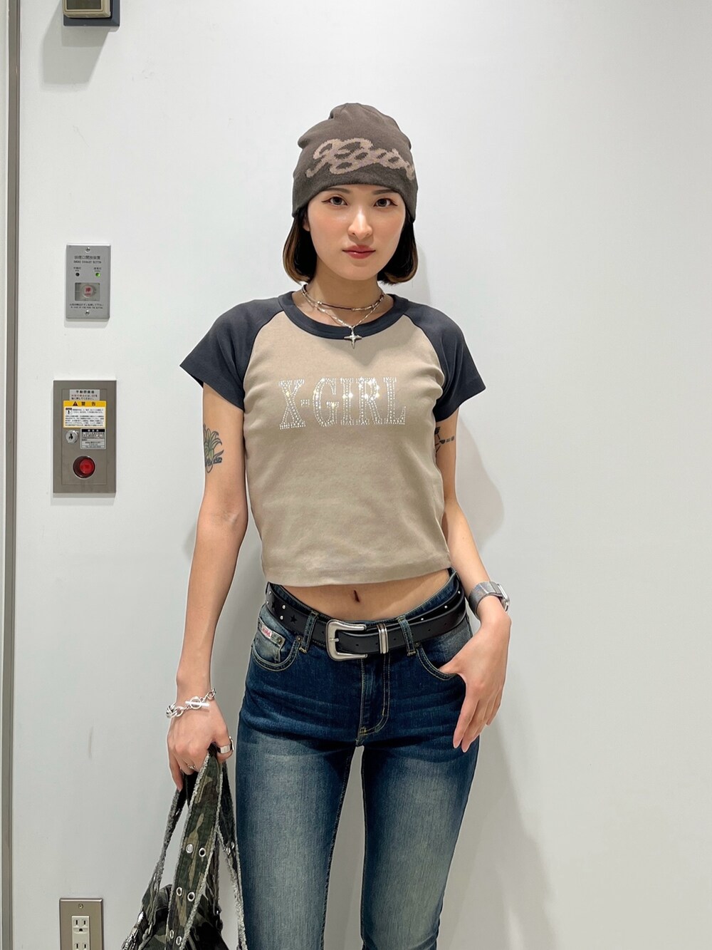 ベージュ系のTシャツ/カットソー、ブルー系のデニムパンツ、その他のハンドバッグを着用したレディースの春コーディネートの3枚目の写真