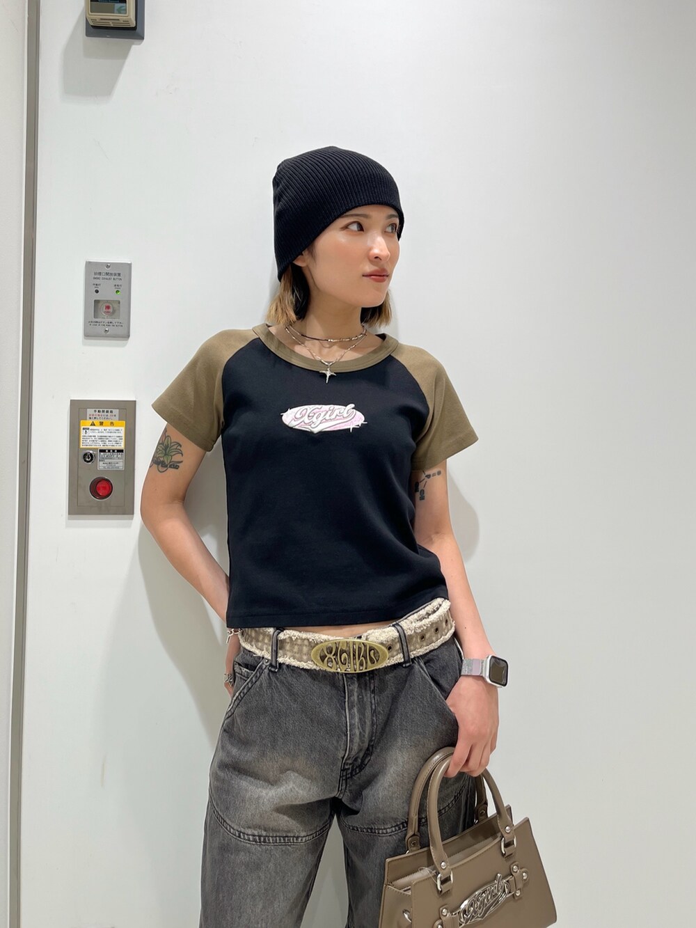 ブラック系のTシャツ/カットソー、ブラウン系のショルダーバッグ、ブラック系のデニムパンツを着用したレディースの春コーディネートの4枚目の写真