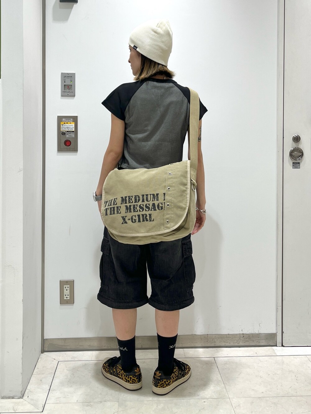 ブラック系のデニムパンツ、ブラック系のTシャツ/カットソー、ブラウン系のショルダーバッグを着用したレディースの夏コーディネートの2枚目の写真