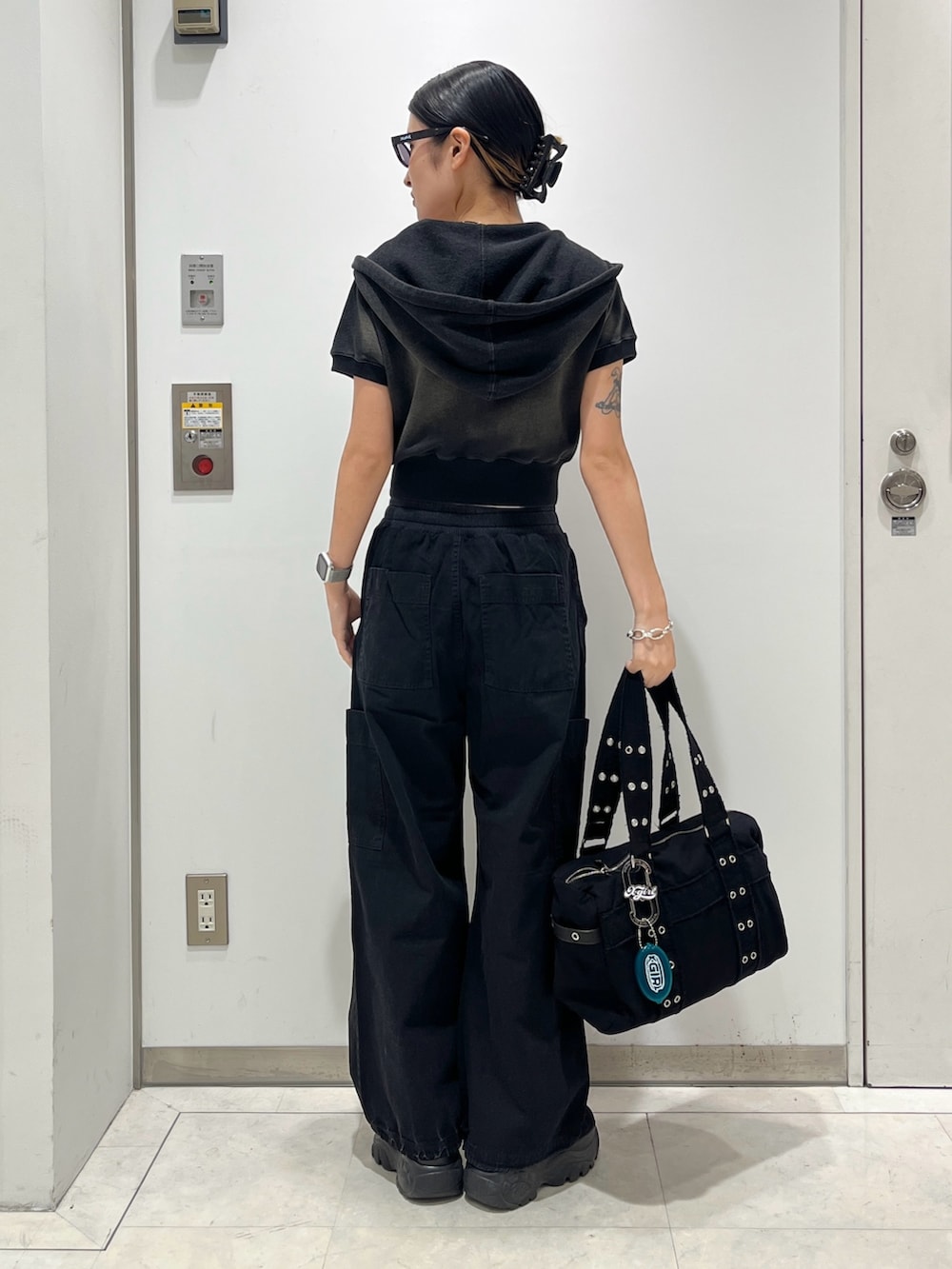 グリーン系のパーカー、ホワイト系のタンクトップ、ブラック系のその他パンツを着用したレディースの夏コーディネートの2枚目の写真