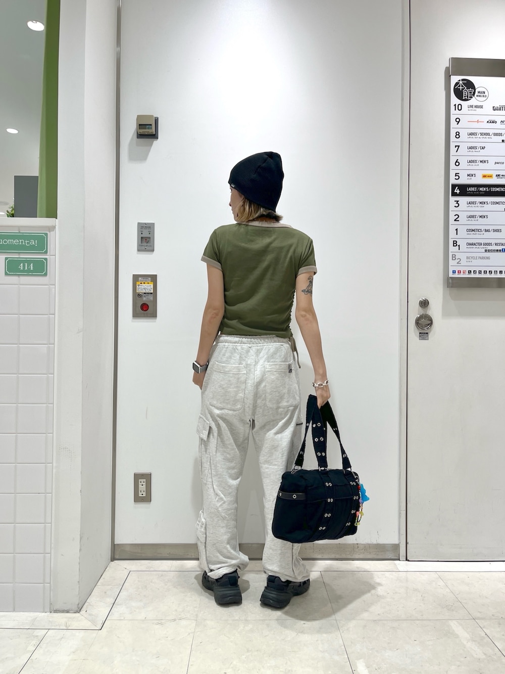 グレー系のスウェットパンツ、グリーン系のTシャツ/カットソー、ブラック系のハンドバッグを着用したレディースの春コーディネートの3枚目の写真