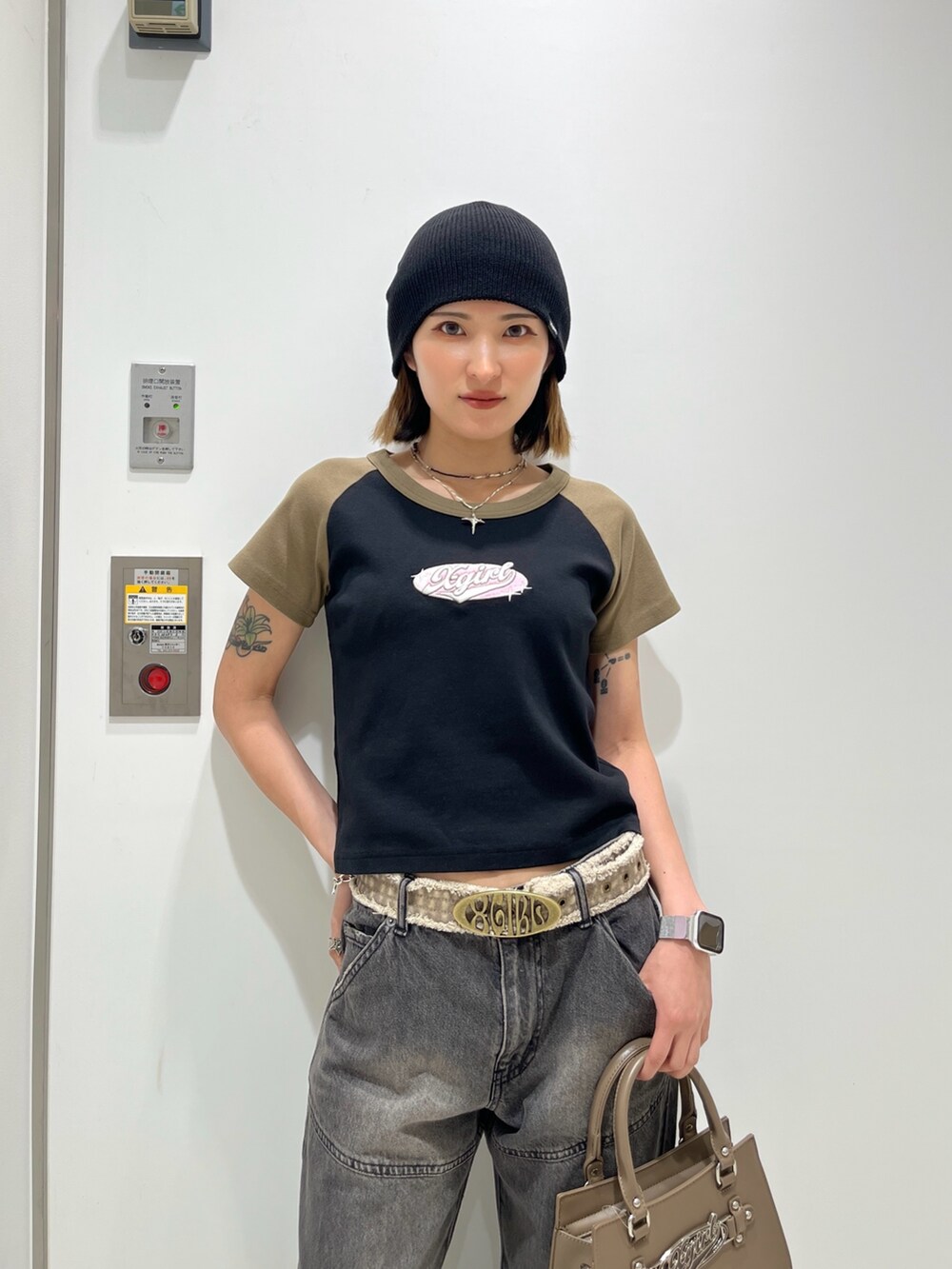 ブラック系のTシャツ/カットソー、ブラウン系のショルダーバッグ、ブラック系のデニムパンツを着用したレディースの春コーディネートの3枚目の写真