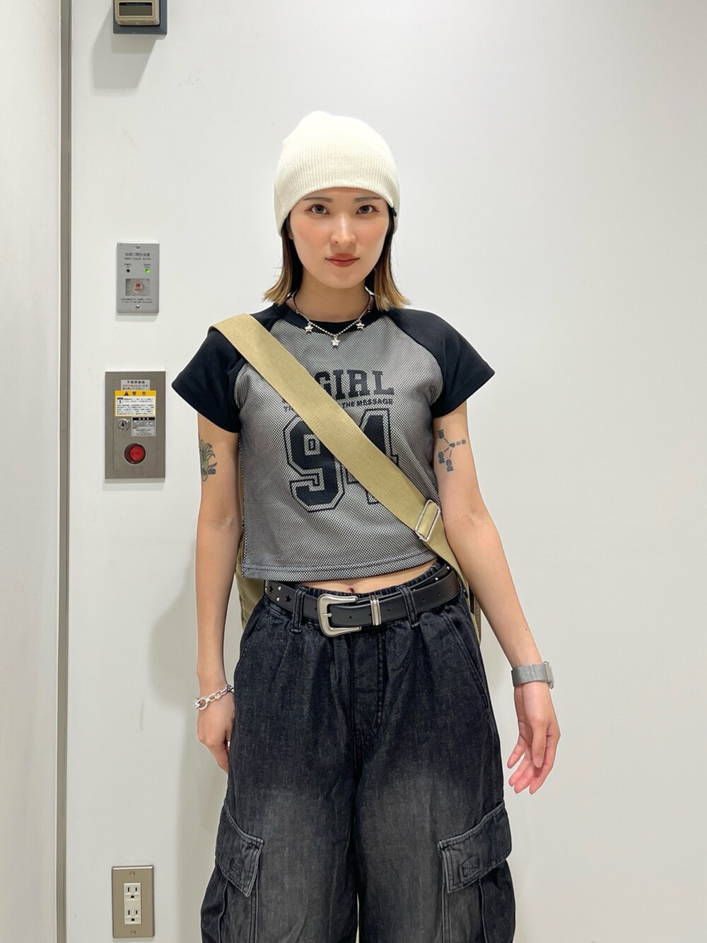 ブラック系のデニムパンツ、ブラック系のTシャツ/カットソー、ブラウン系のショルダーバッグを着用したレディースの夏コーディネートの3枚目の写真