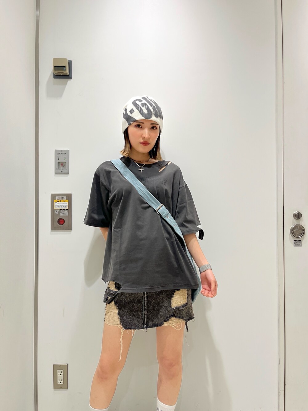ブラック系のTシャツ/カットソー、ブラック系のデニムスカート、ブルー系のショルダーバッグを着用したレディースの夏コーディネートの4枚目の写真