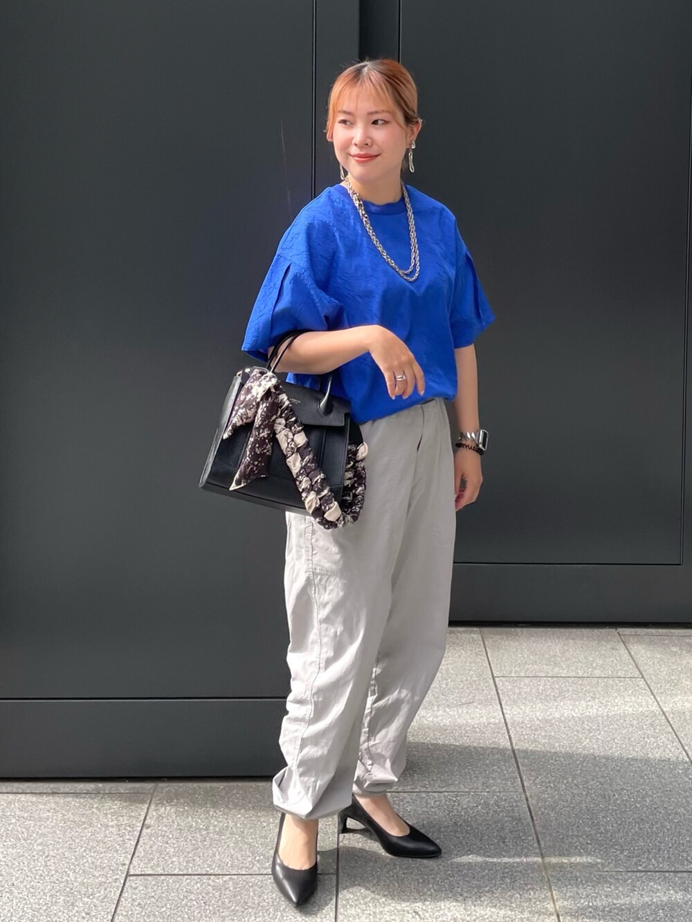 ブルー系のTシャツ/カットソー、ブラック系のショルダーバッグ、ブラック系のパンプスを着用したレディースの夏コーディネートの2枚目の写真