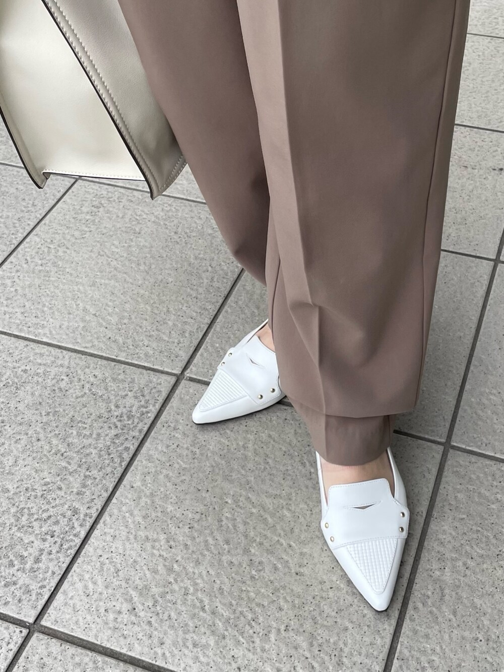 ホワイト系のパンプス、ホワイト系のトートバッグを着用したレディースの夏コーディネートの2枚目の写真